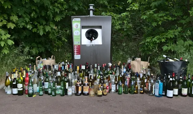 muchas botellas en contenedor de basura