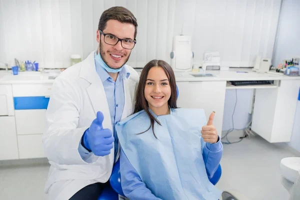 Medico dentista y paciente sonriendo