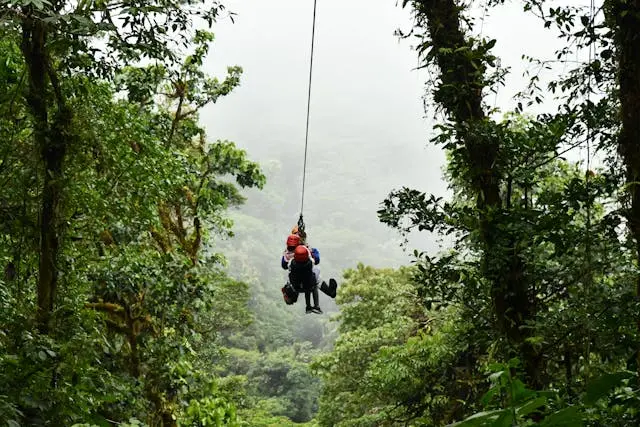 dos personas lanzandose en tirolesa