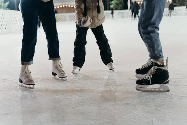 tres personas patinando sobre hielo