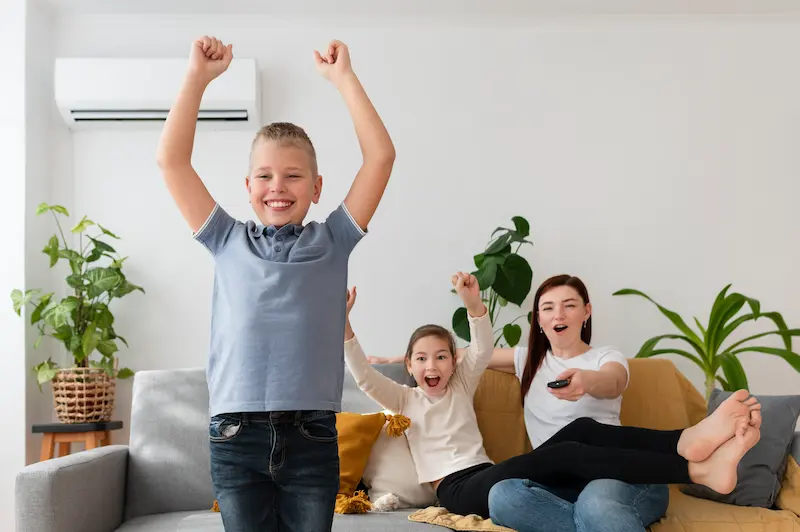 Mamá viendo la televisión con sus hijos.